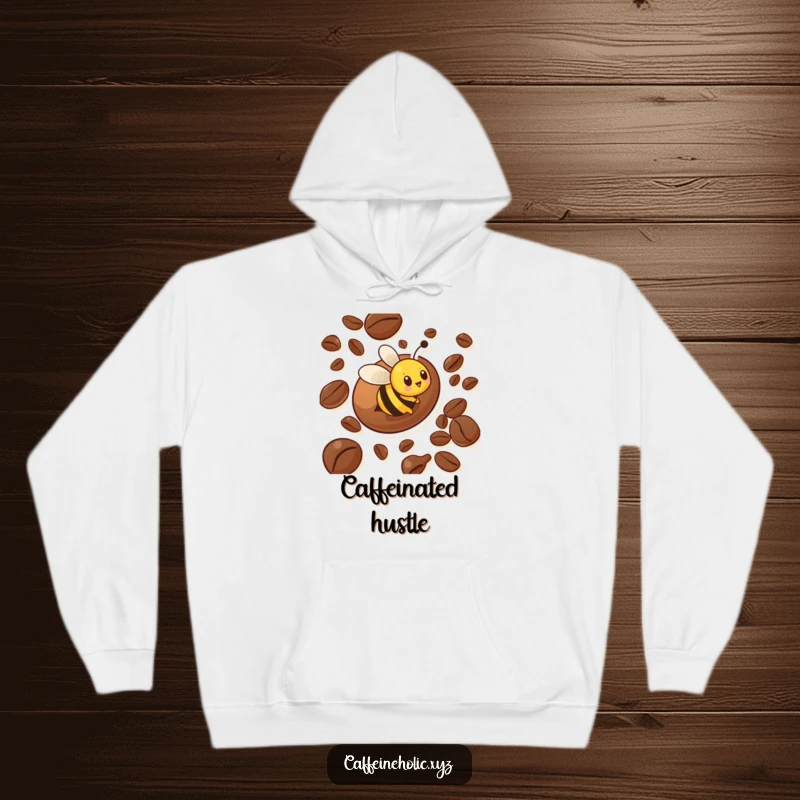 Funny hoodie depicting a busy bee character actively zooming around a large coffee bean, offering warmth and humorous appeal.
